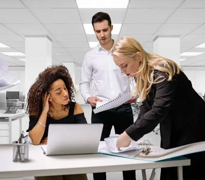 Denkweisen von Mittelmanagern dargestellt als Büroszene, wobei ein Mann und eine Frau auf eine andere Frau im Büro einreden.