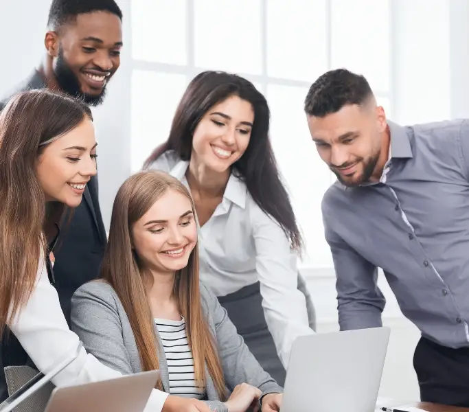 Zukunft des Mittelmanagements symbolisiert durch fünf junge Führungskräfte, die auf einen Laptop schauen